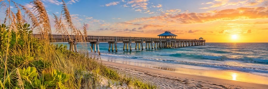 Juno Beach pier stretching over the Atlantic Ocean at sunrise in Florida