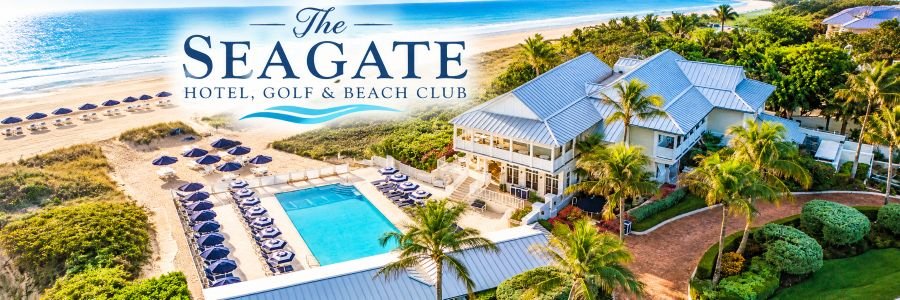 Aerial view of a luxury beachfront property with a turquoise swimming pool, navy beach umbrellas, palm trees, and a sandy Atlantic shoreline.